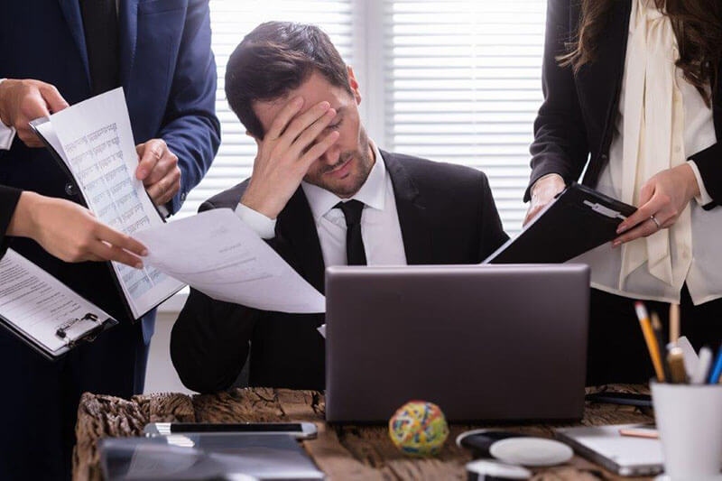 man stressed and over worked at his desk